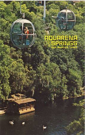 Green, retro postcard of an illustration of people in cable cars hanging suspended over the water, forest in the background. In bright yellow font it reads: "Aquarena Springs -- San Marcos, Texas"