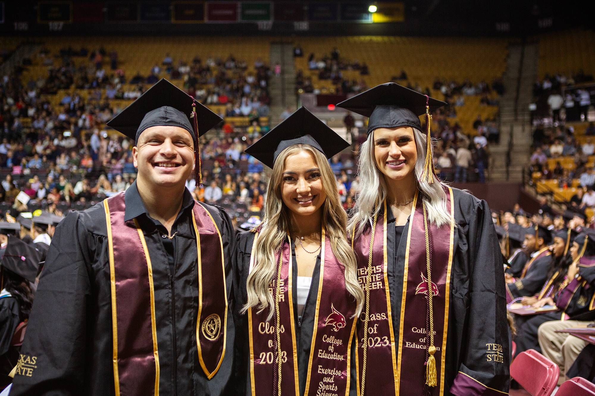 three graduates pose for a group photo