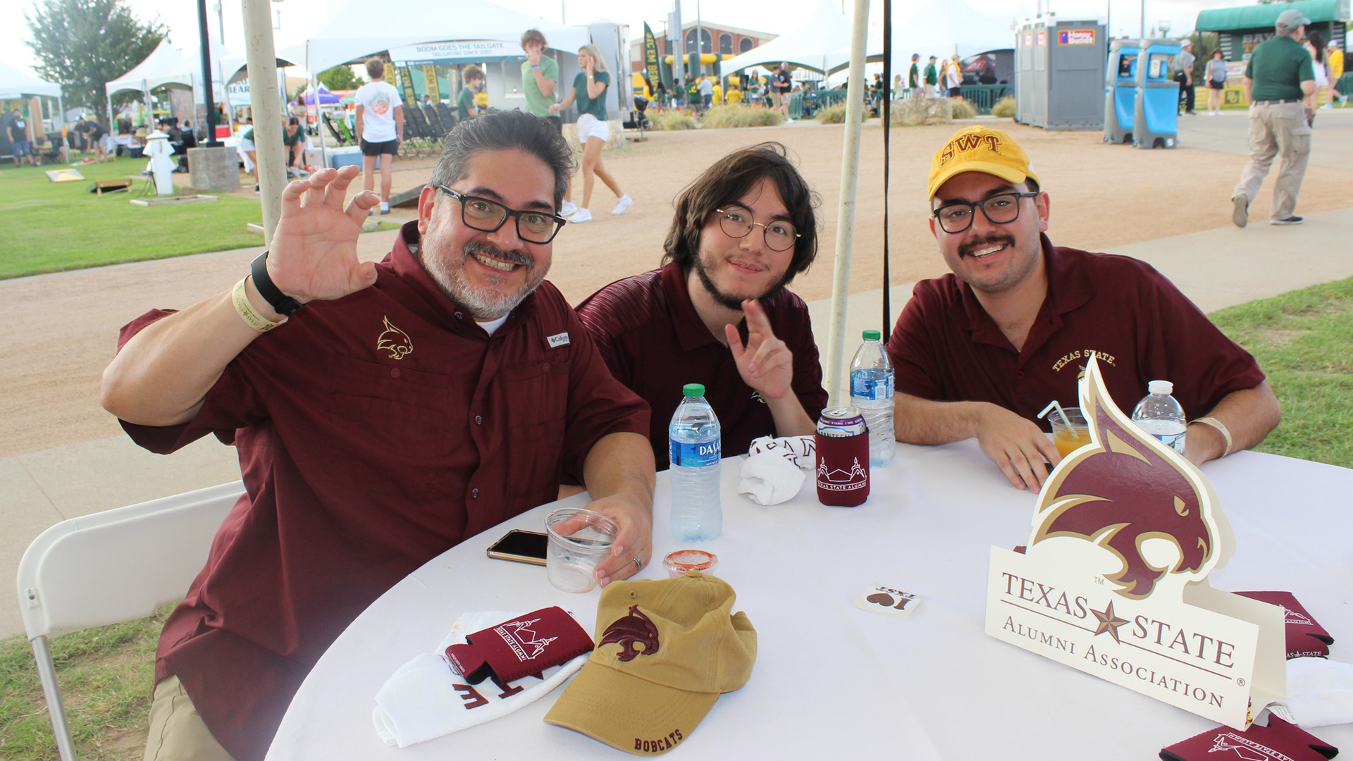 group of men wearing bobcat merch sitting at the table