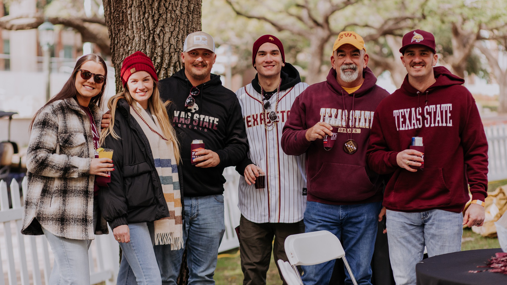 group photo of six people wearing texas state merch at an alumni tailgate event