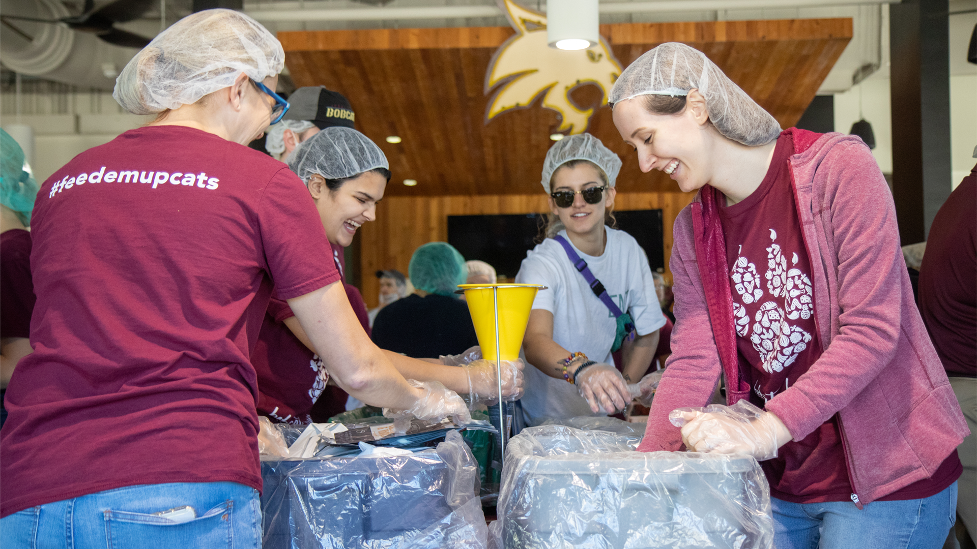 group photo of people wearing texas state shirts serving food