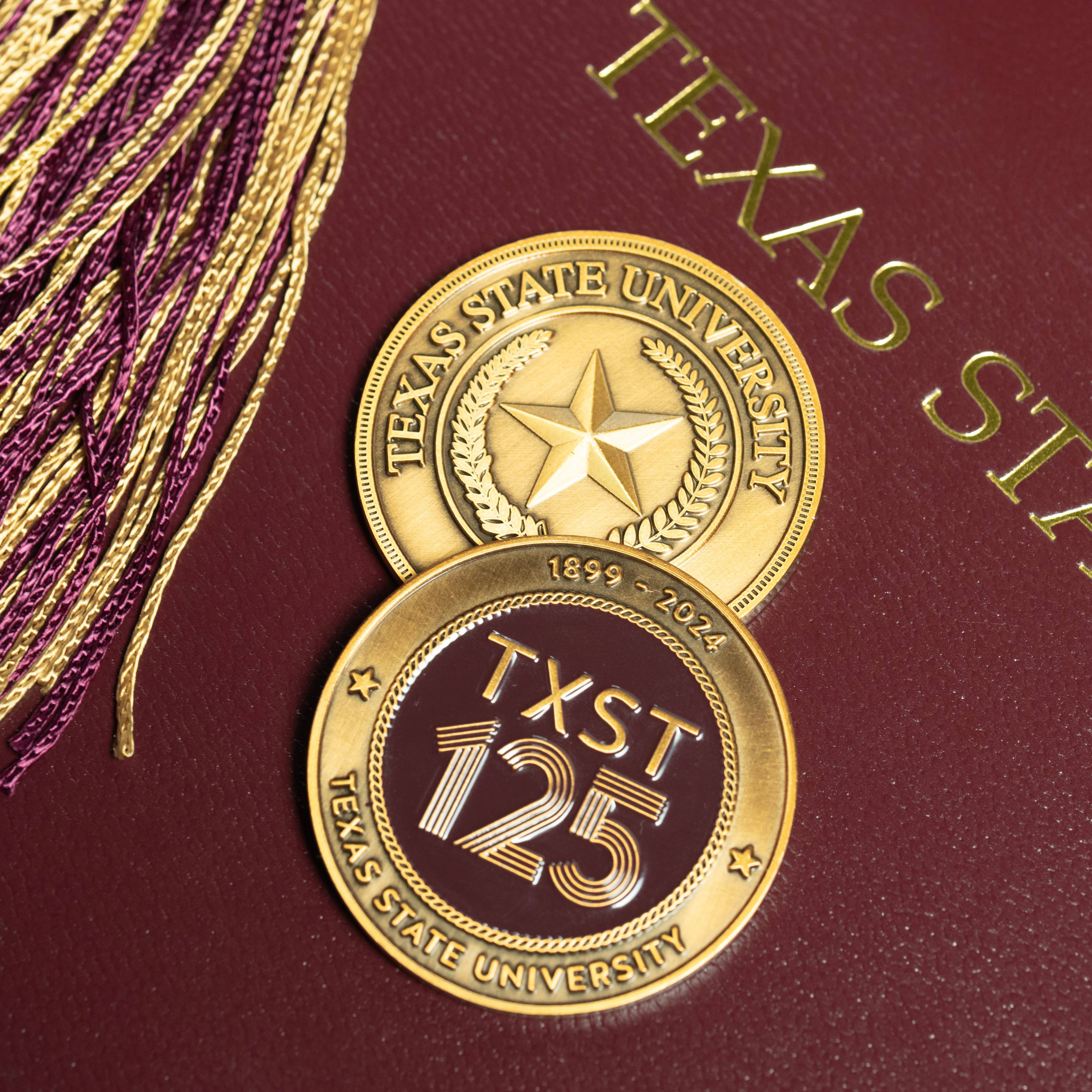 close up of two challenge coins on maroon background