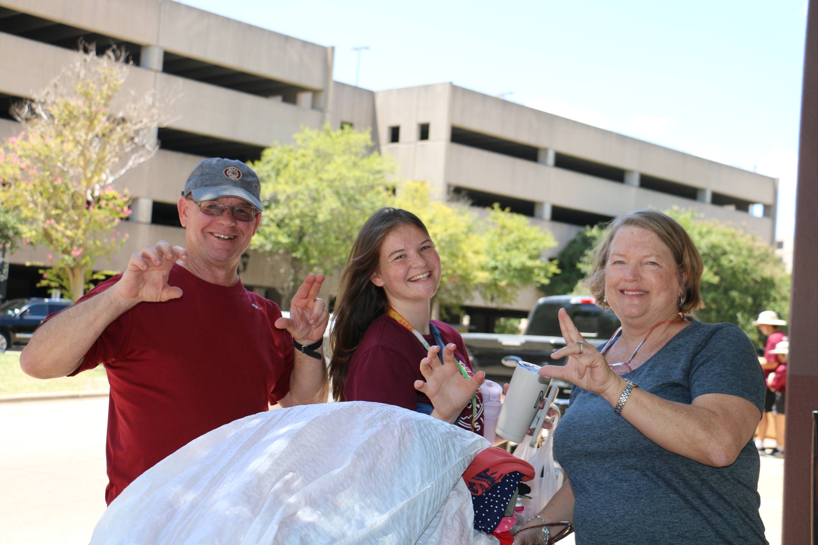 three people holding a states up hand sign
