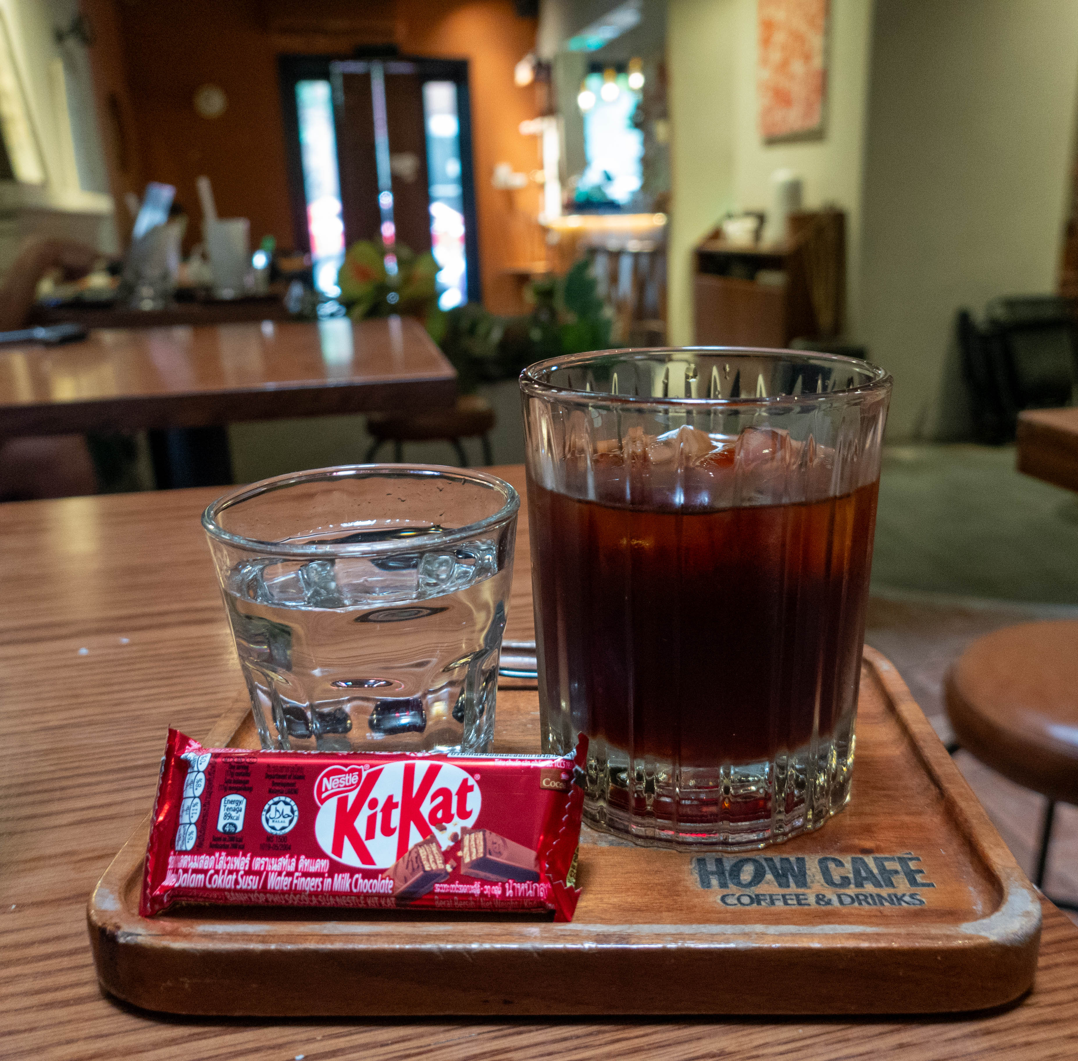 picture of shot glass of water, glass of iced coffee, and small KitKat candy bar