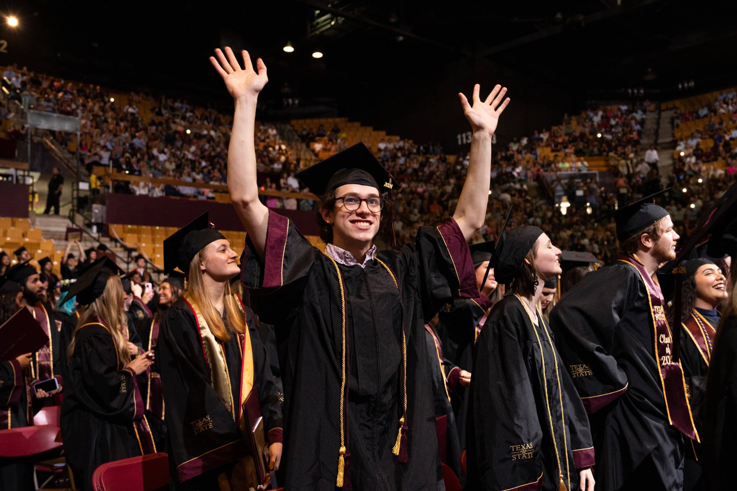 a student waiving during a commencement ceremony