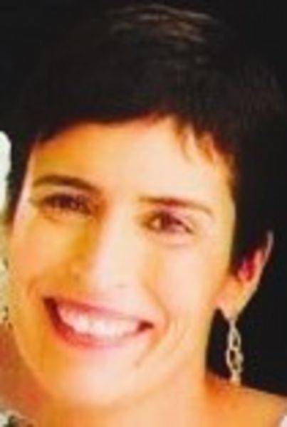 close-up of woman smiling, one earring visible