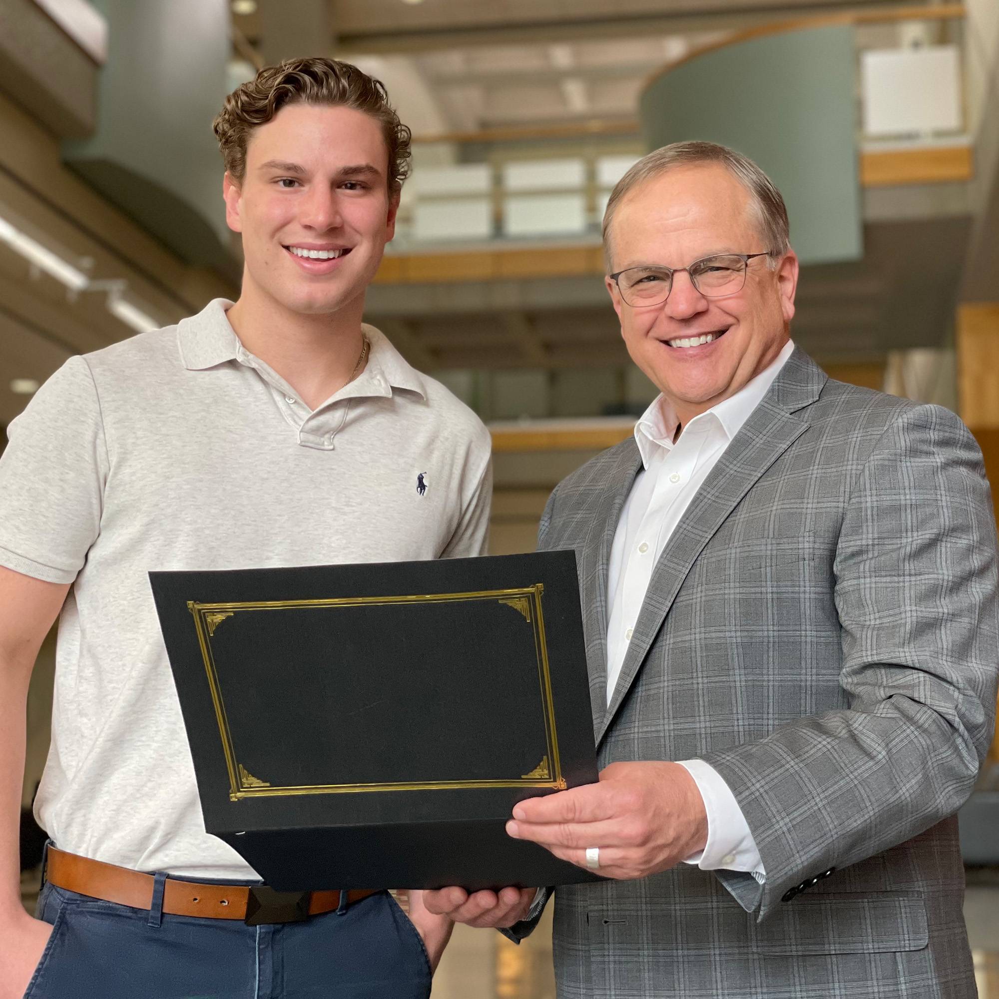 Two men holding a certificate