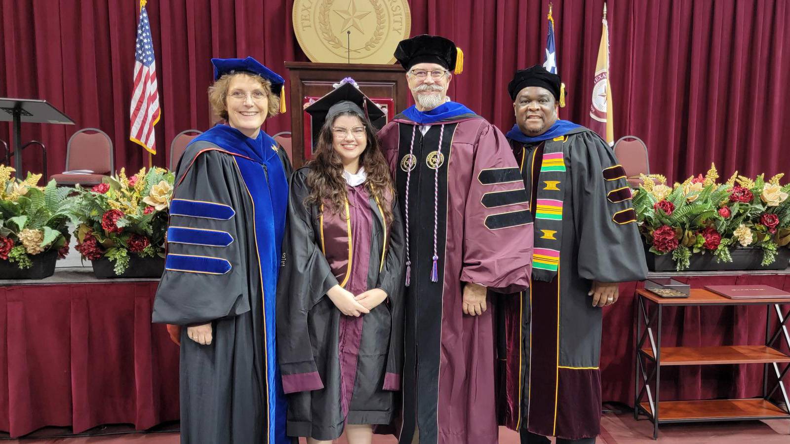 Dean Andrea Golato (left), Anna Marie Elliott, Kevin Elliott, and Dr. Scott W. Bowman, pose for a photo on stage at Spring 2024 Commencement.