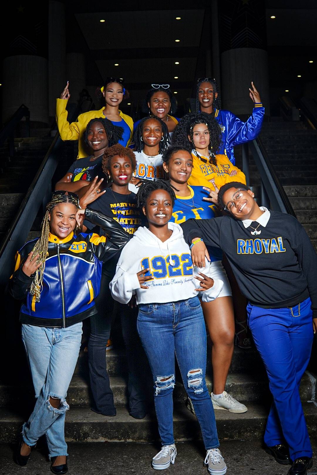 Women of Sigma Gamma Rho wearing their organizations' colors and showing their hand signs while tabling in the LBJ Student Center Ballroom