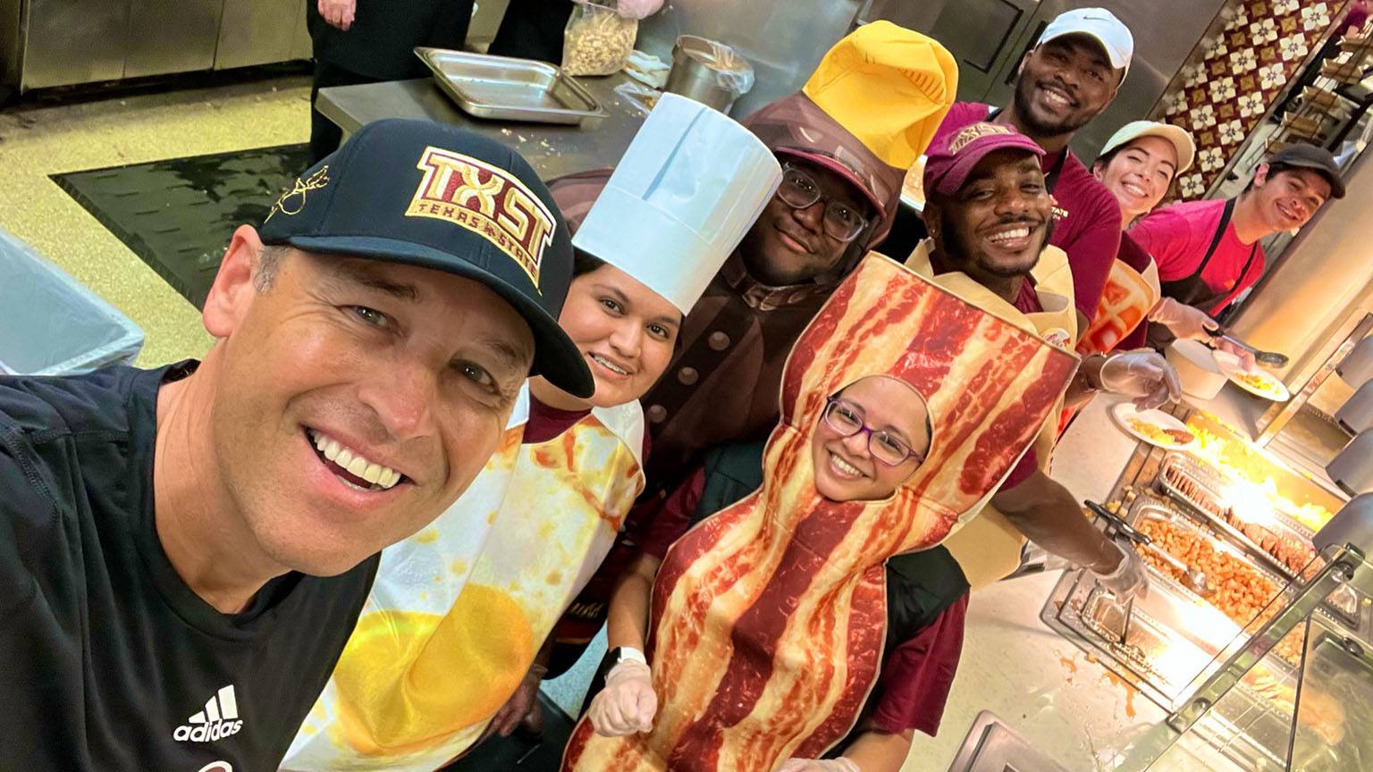 President Damphousse (left) poses for a photo with food servers at the Late Night Breakfast event.