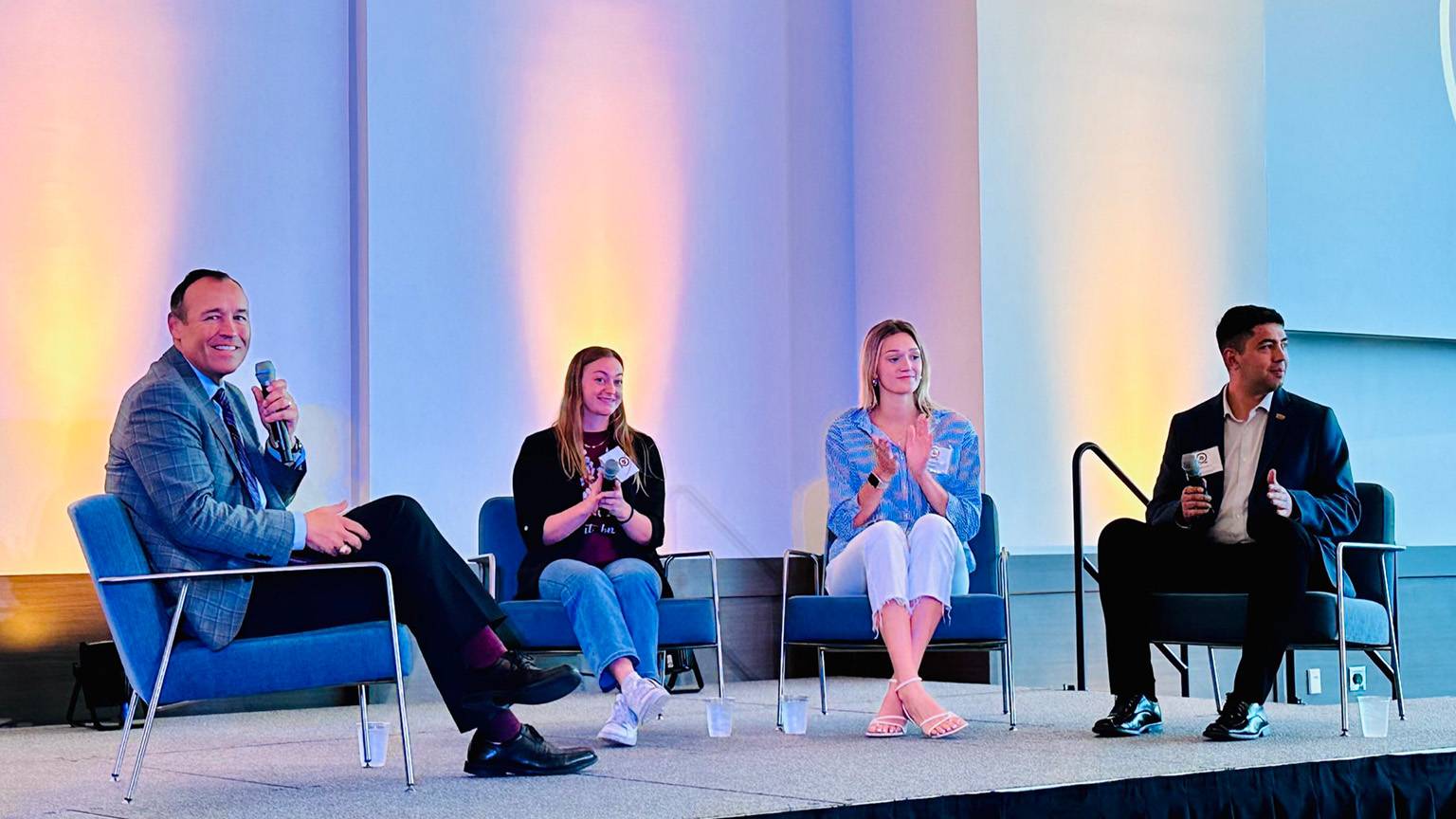 President Damphousse (left) poses for a photo on stage with student panelists.