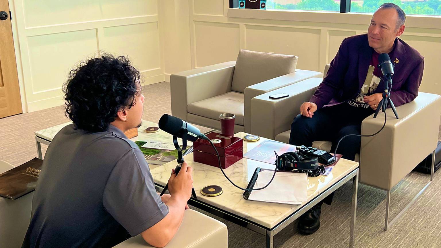 Tyson Taylor (left) asks President Damphousse a question for a podcast.