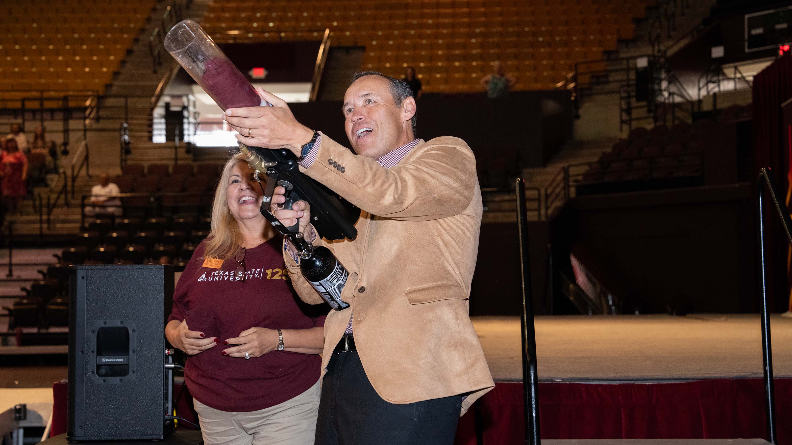 President Damphousse shoots a t-shirt canon into the crowd in the University Events Center.