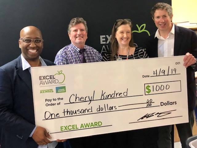 Kindred receives a $1000 check from Credit Human for winning the Excel Award