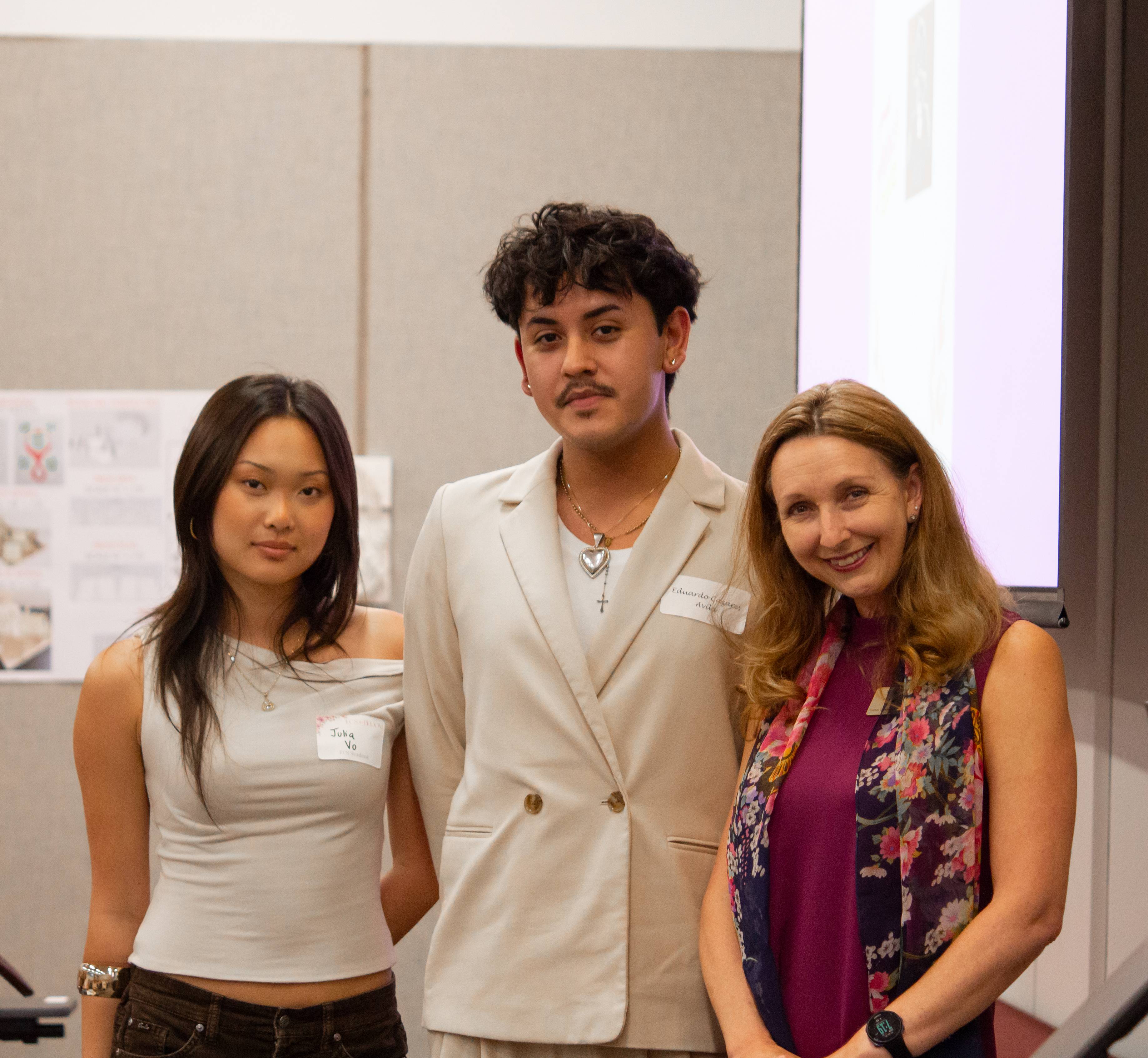 a group of students standing next to a faculty member in a classroom 