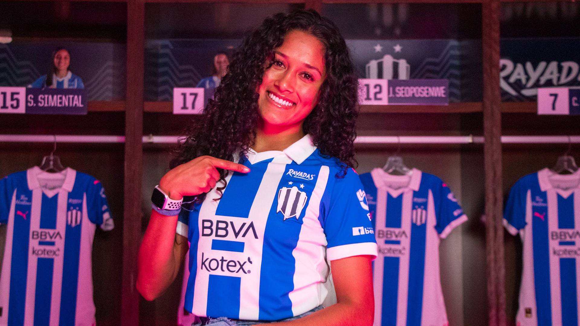 Juana Plata in the locker room pointing to her C.F. Monterrey Femeni jersey