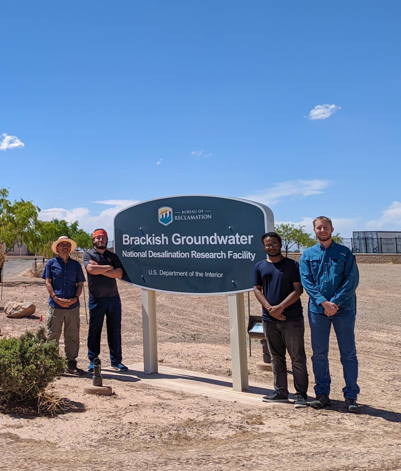 4 people standing in front of Brackish Groundwater Desalination Research Facility in New Mexico
