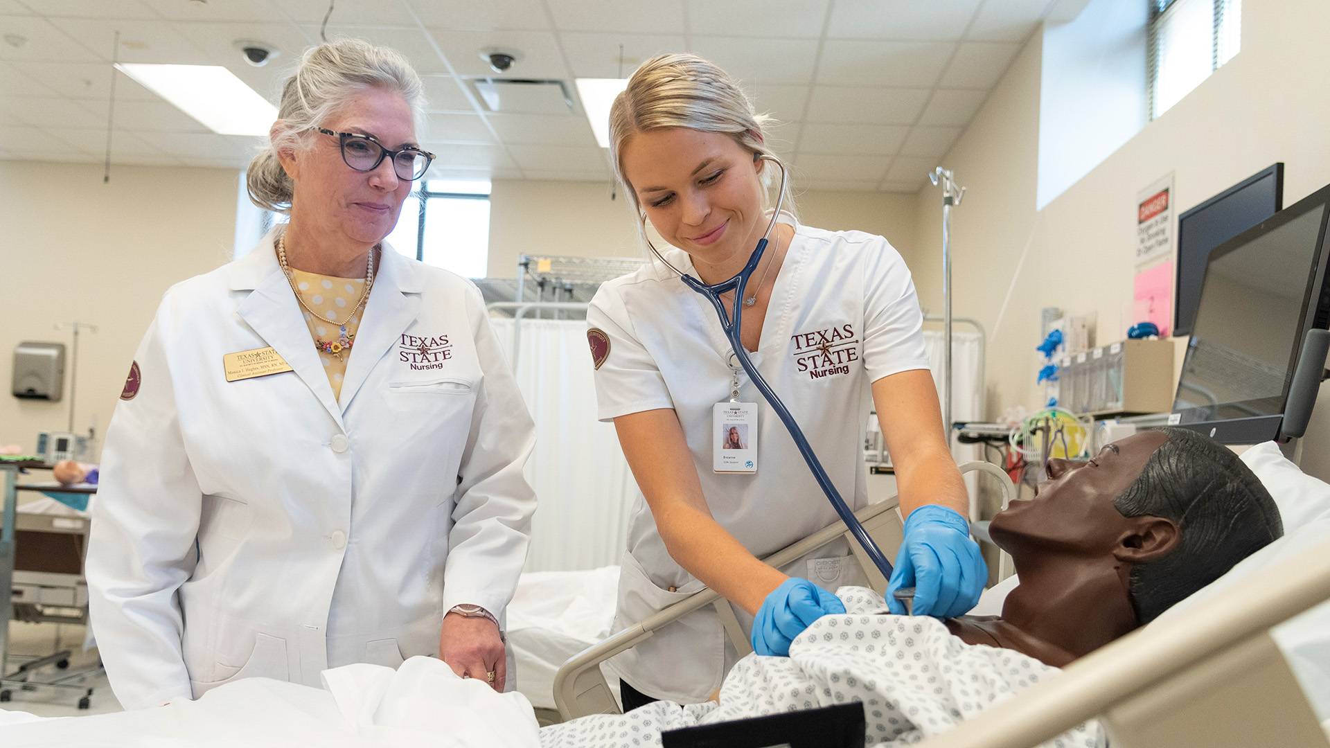 Nursing student conducting nursing simulation with professor 