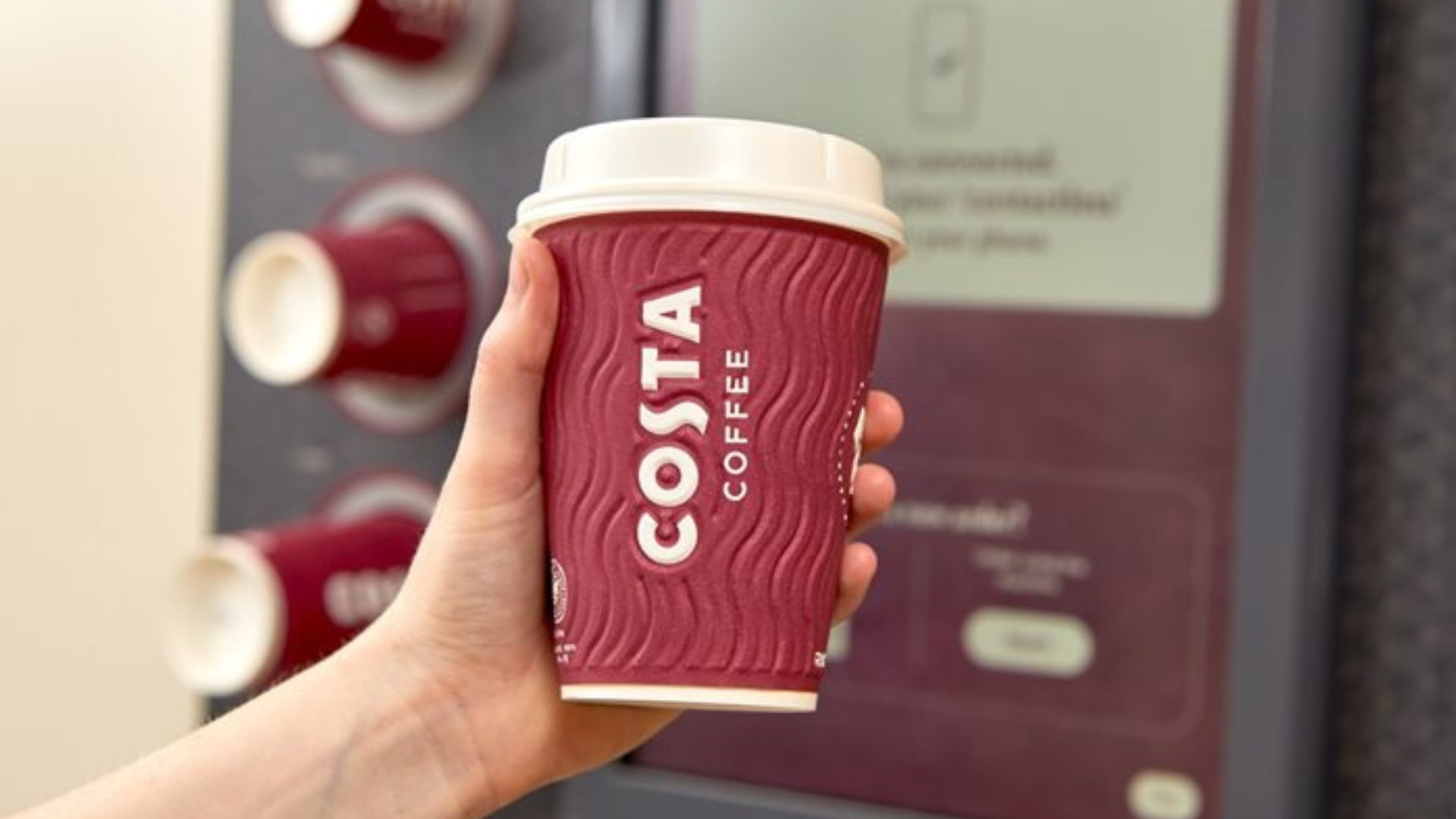hand is holding a costa coffee cup