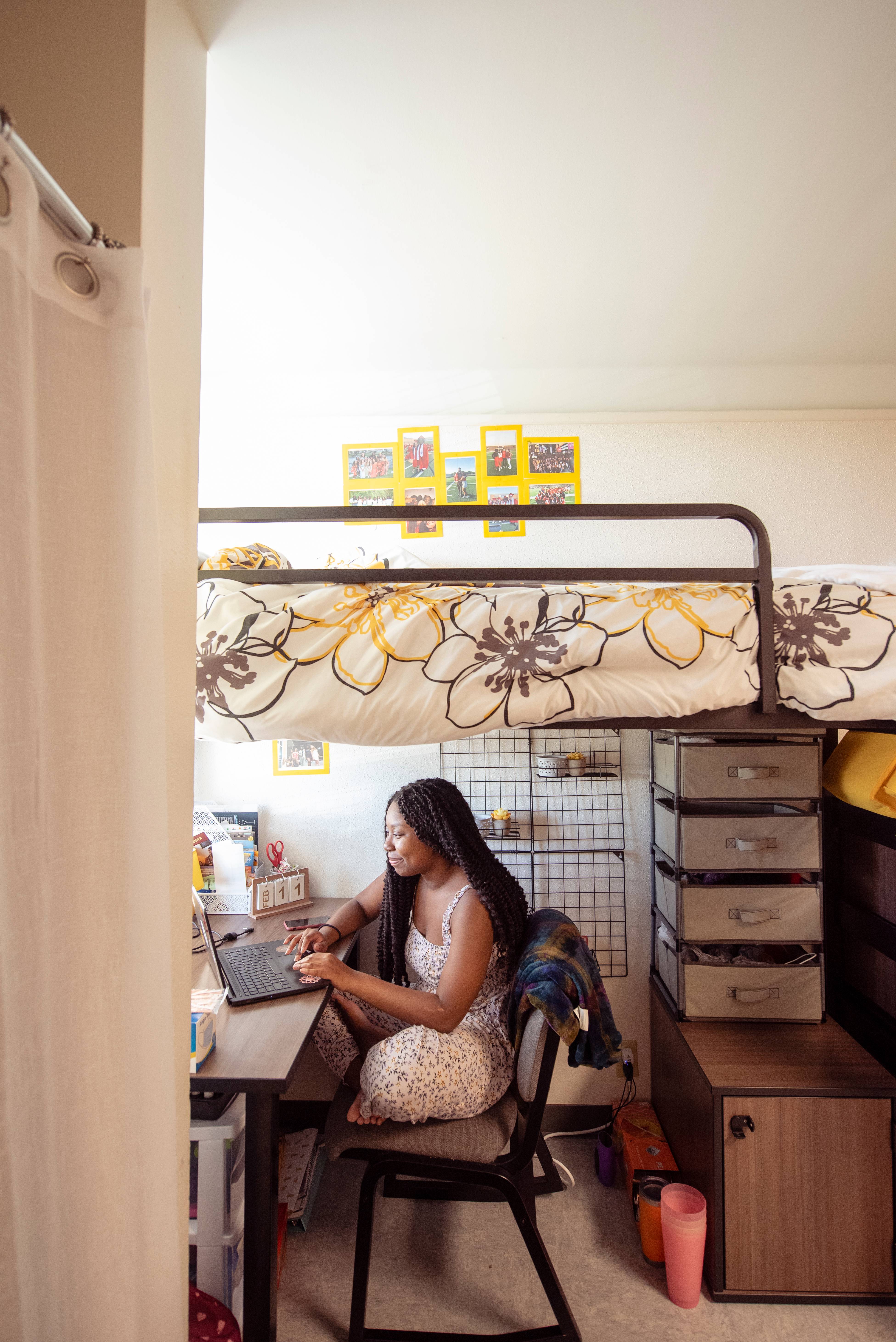 women sitting at a desk under a lofted bed