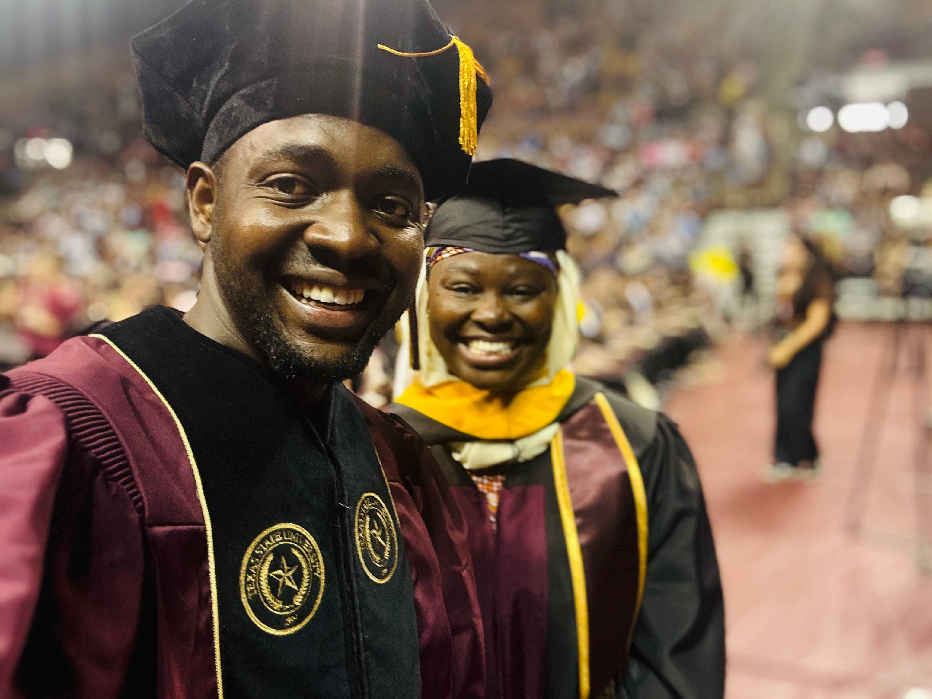 two graduates posing together during commencement