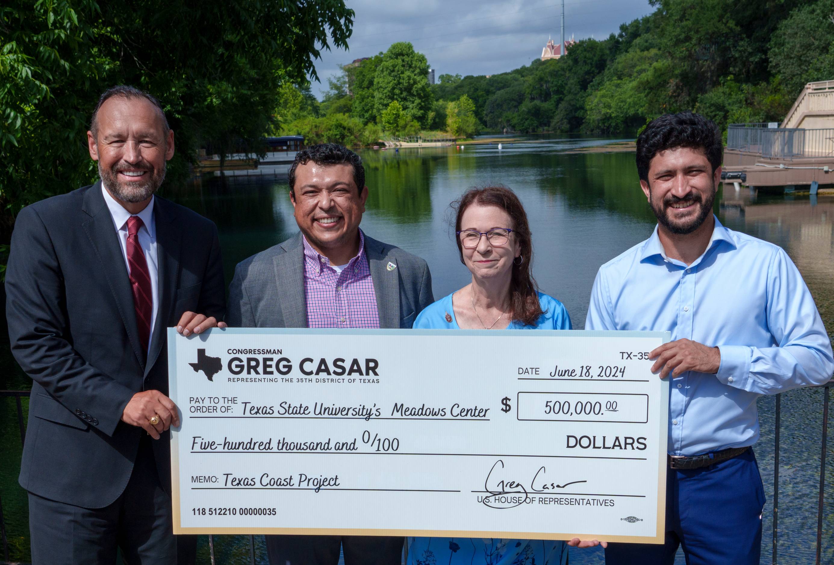 a group photo of people holding a check 