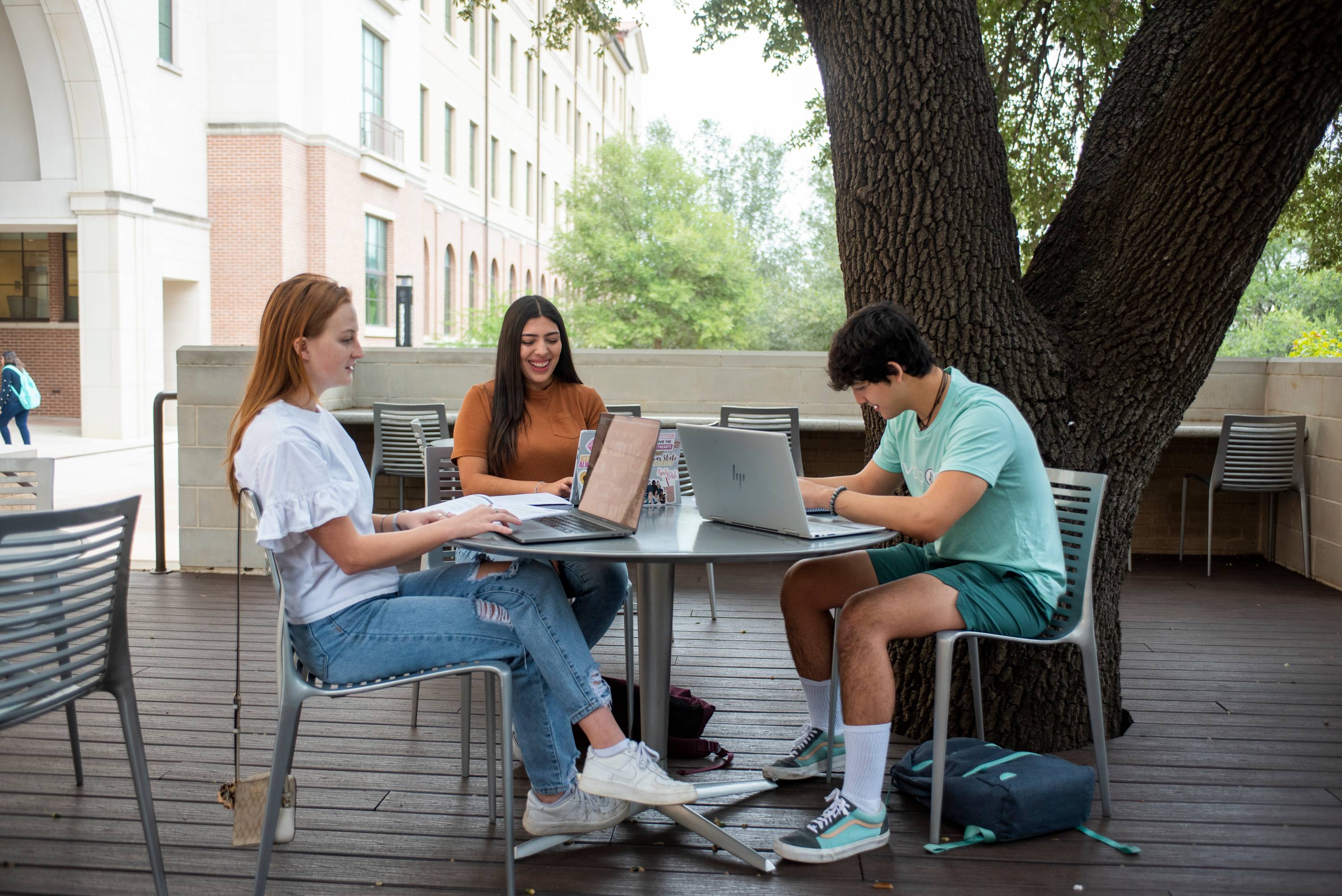 people outside on laptops