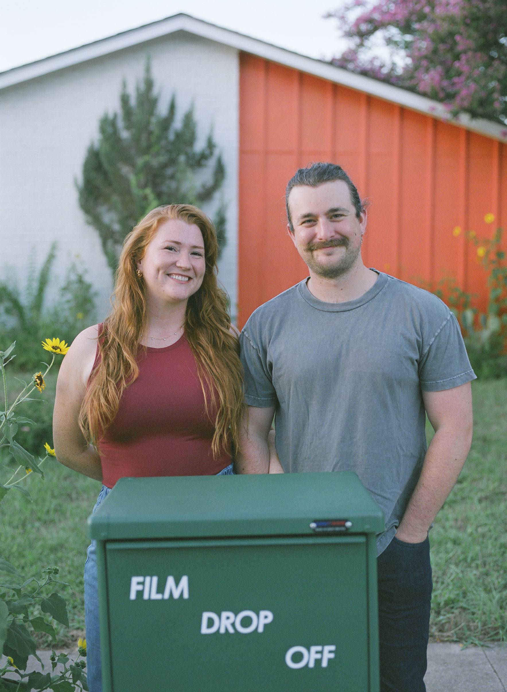 TXST alum Holly McVeety-Mill (left) and husband AJ Gerstenhaber stand next to their film drop box outside their home in Austin.