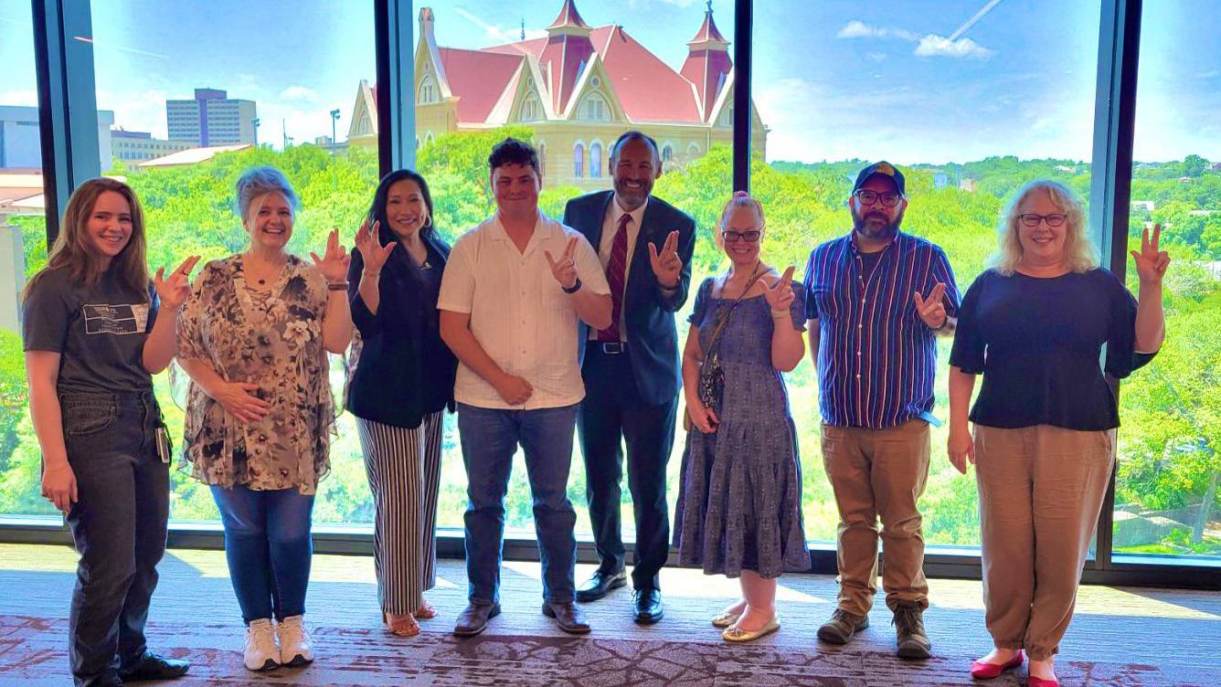 President Damphousse (left) poses for a photo with a group of TXST staff.