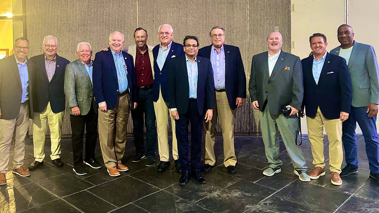 President Damphousse poses for a photo with a group of Sun Belt Conference CEOs.