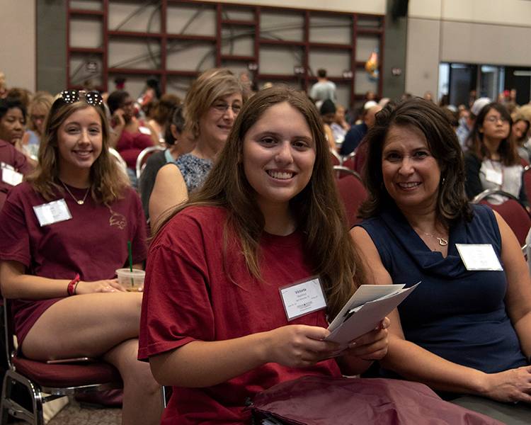 Student sitting next to her parent