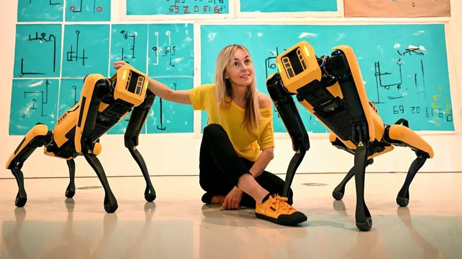 Young woman posing with two robots
