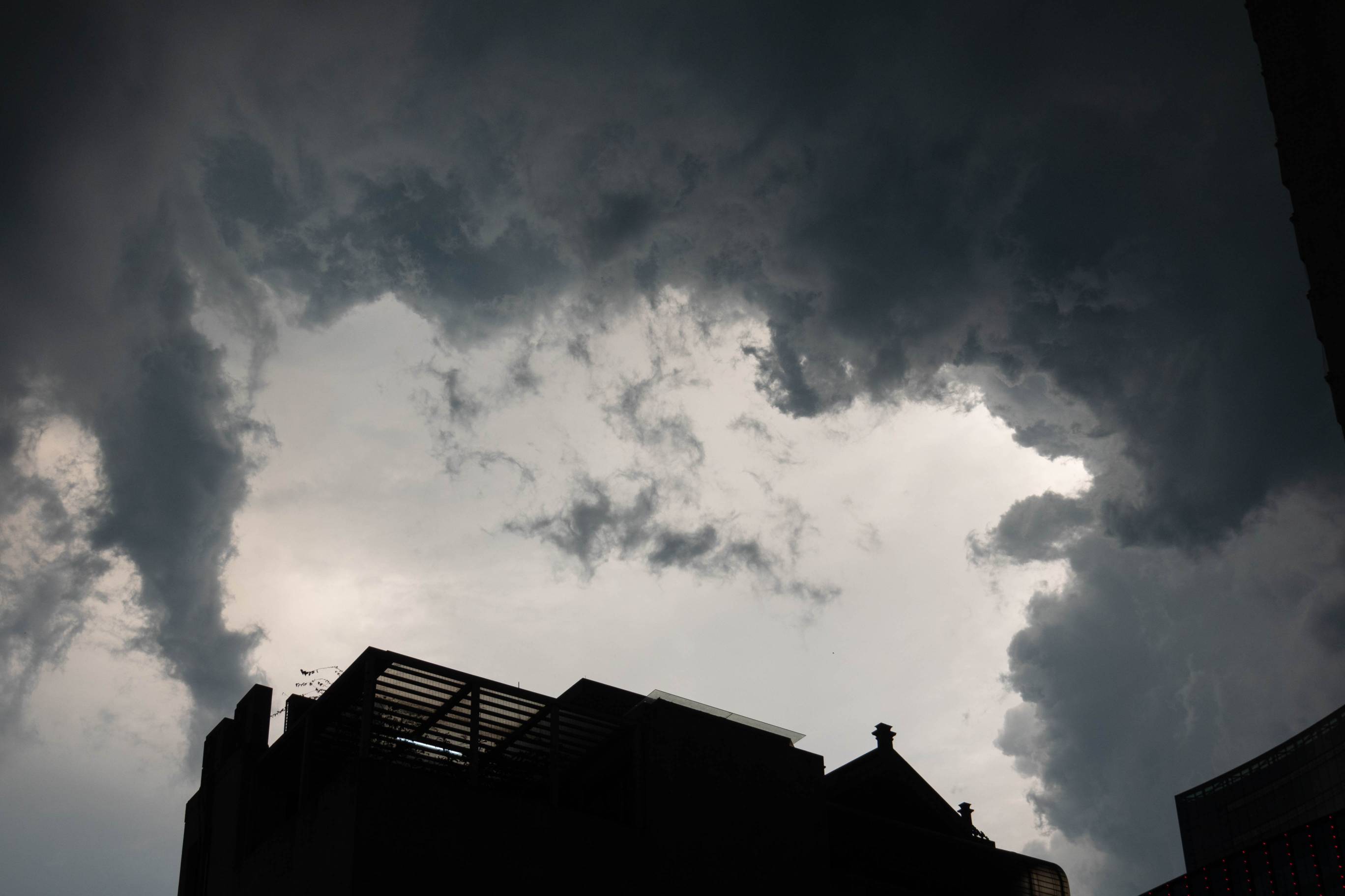 picture of dark gary and black clouds above a dark building at bottom of picture.