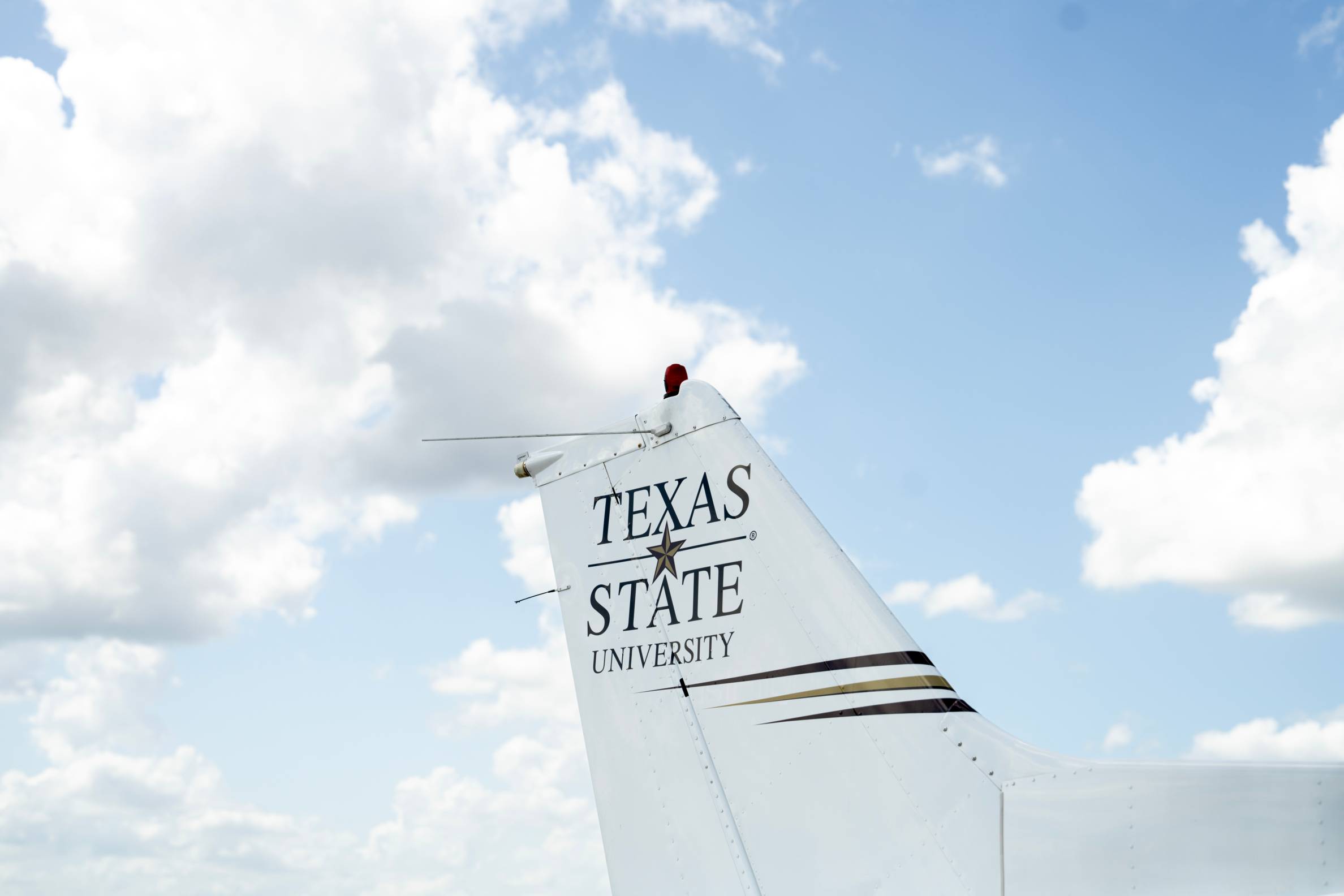 Tail on plane with Texas State University name and logo