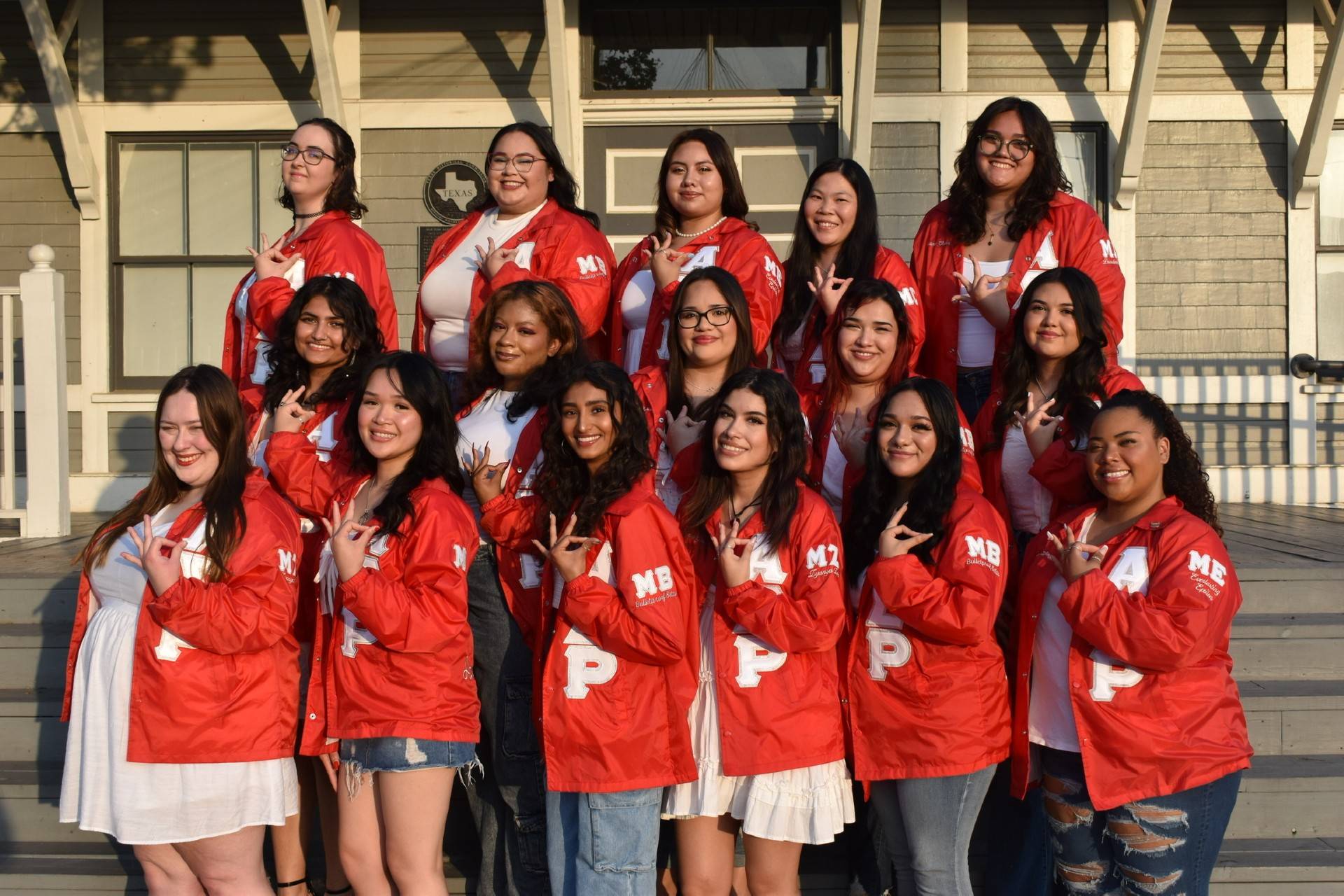 Women of Alpha Sigma Rho surrounded by organization memorabilia