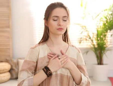 a woman relaxing with her eyes closed, crossing her hands over her heart