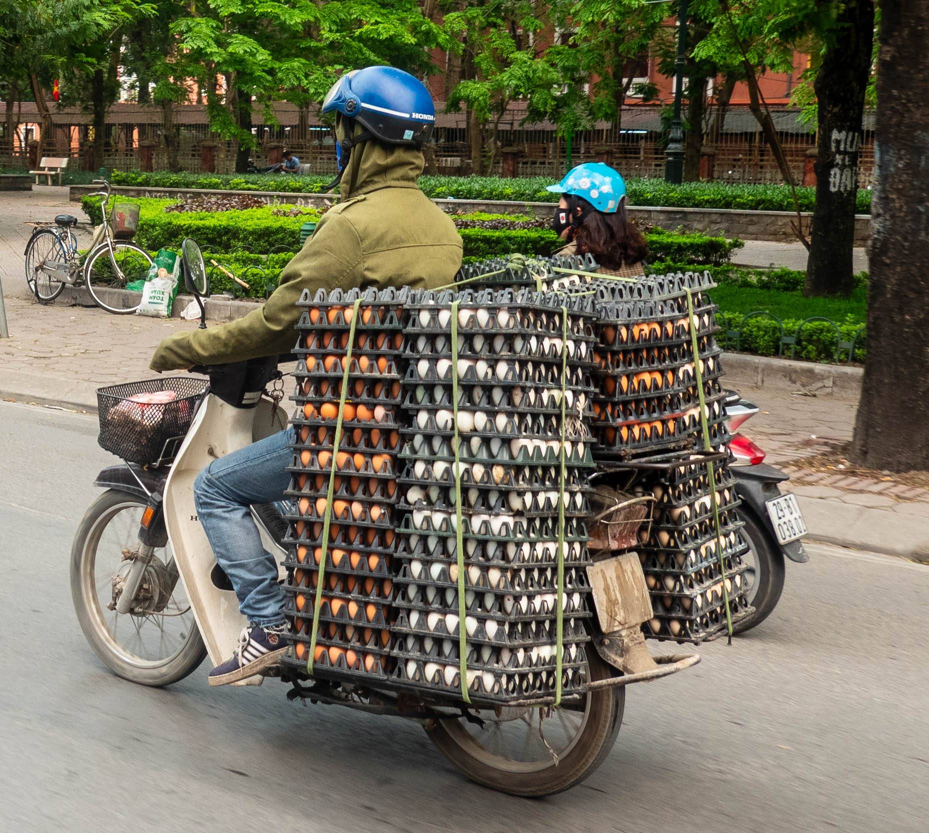 motorbike carrying stacked egg crates full of eggs