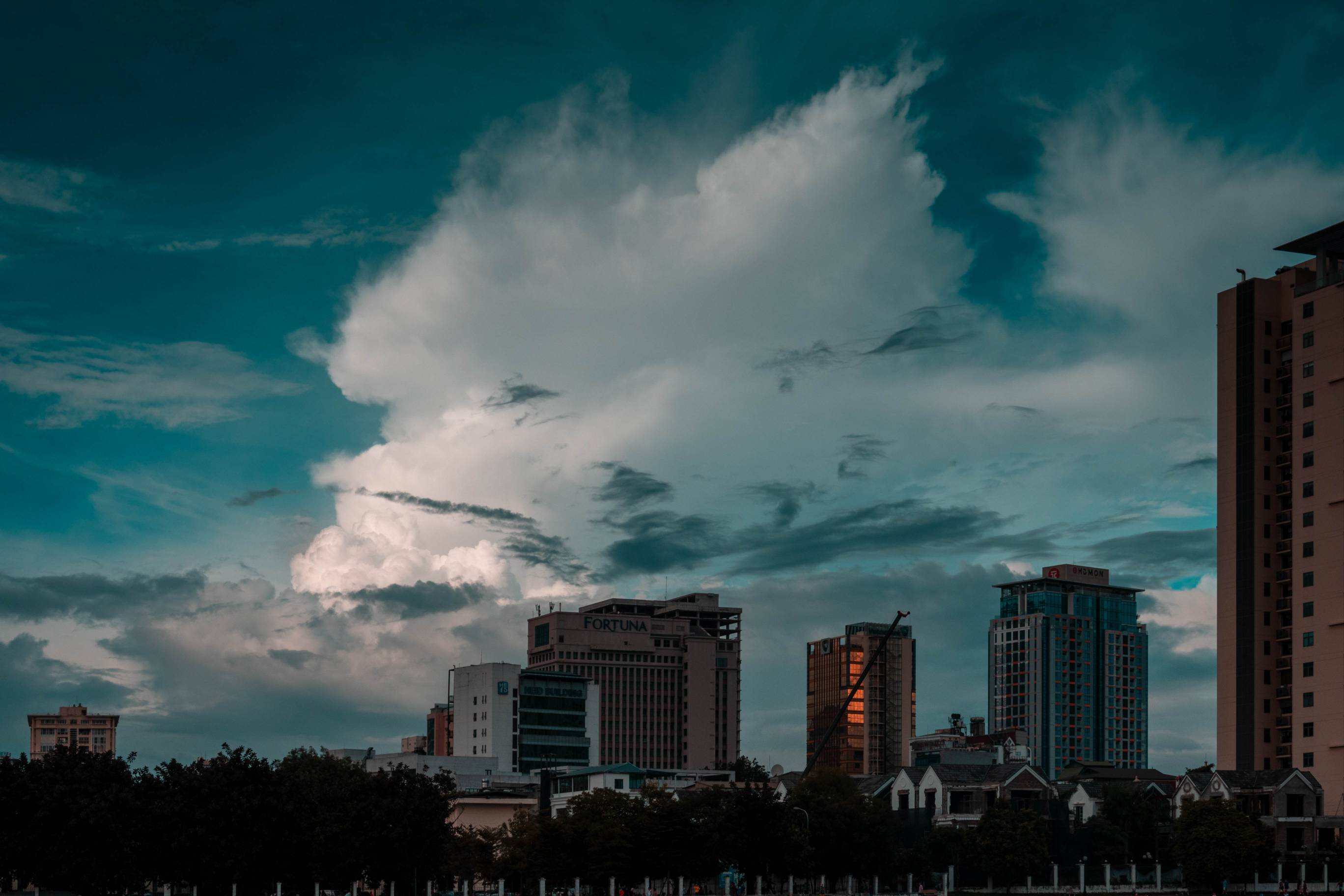 Clouds above buildings look like the could be a Vietnamese lion's head.  Sky color is more tuquoise than blue.