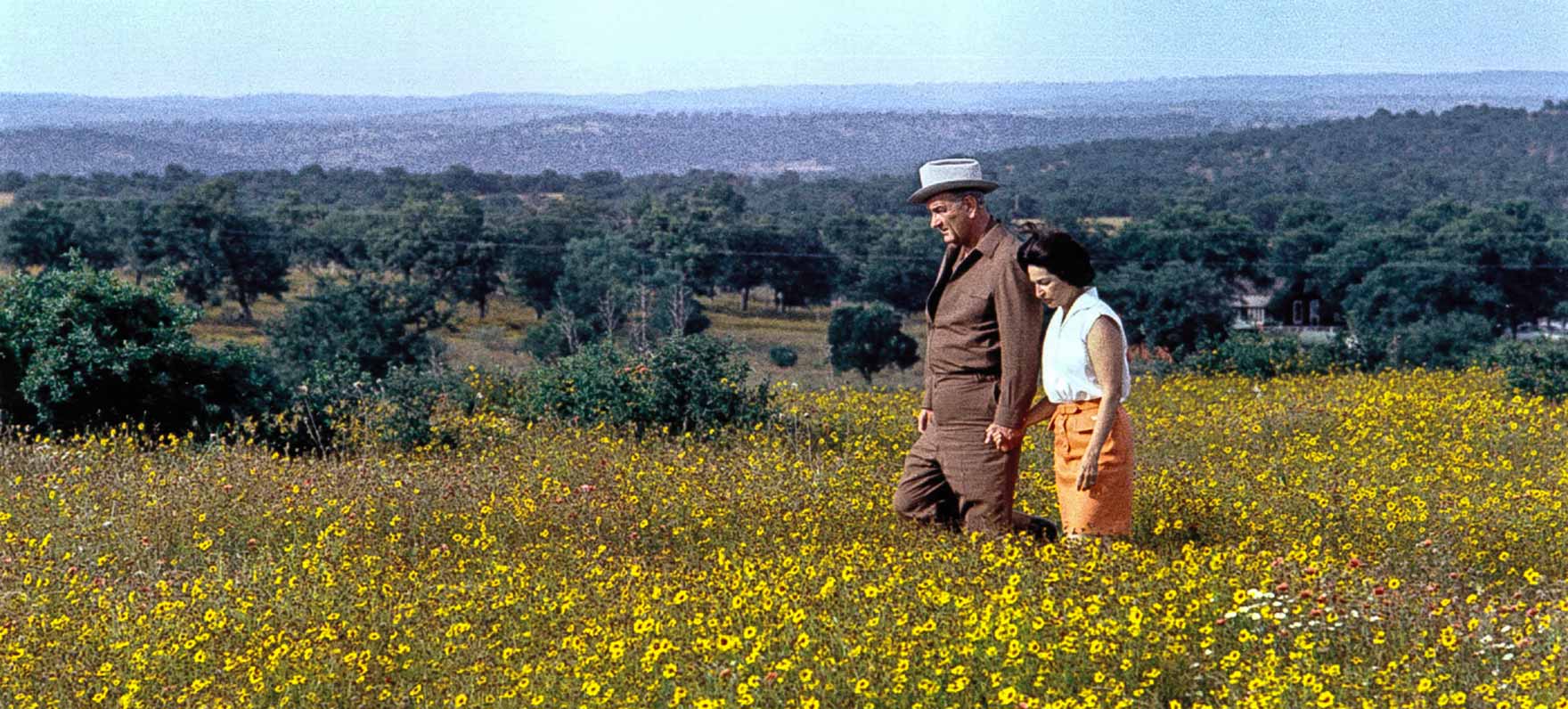 President Johnson and Lady Bird Johnson walk through a field of wildflowers on LBJ Ranch in Stonewall, TX.