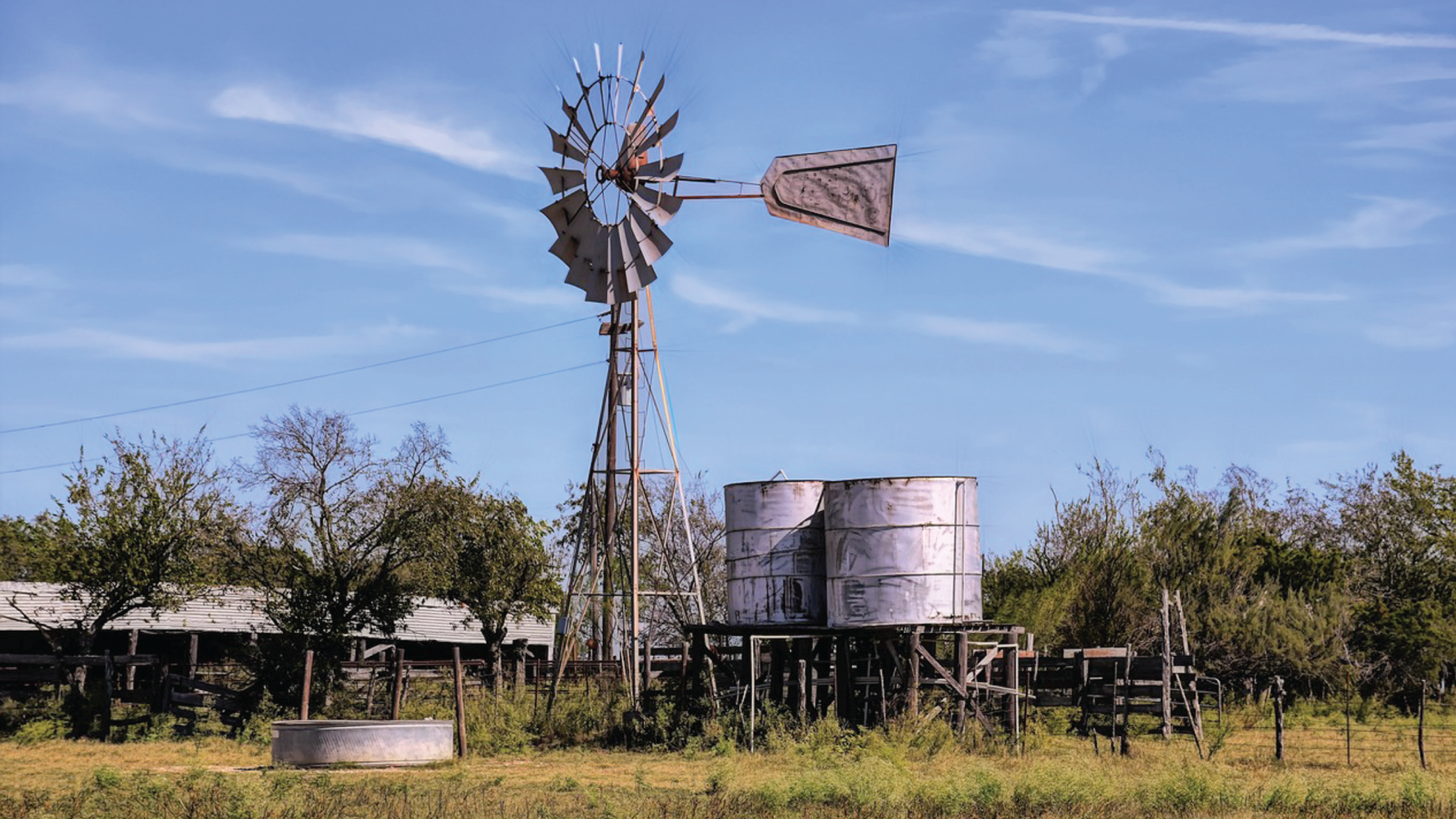 A rural farm with a windmill is shown.