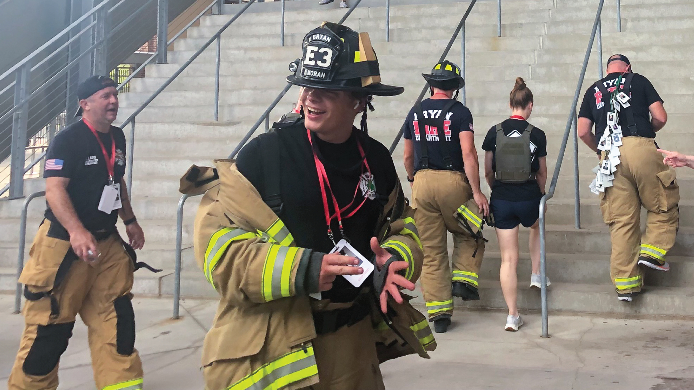 Firefighters walking up a stadium staircase.