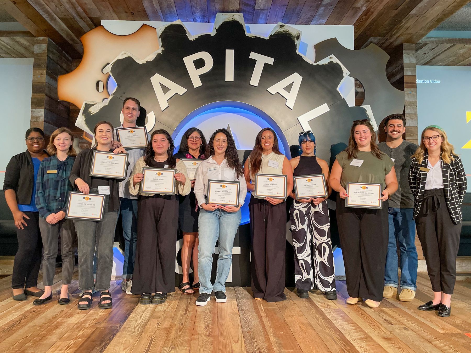 Visualizing Mental Health Training graduates stand together holding their certificates.