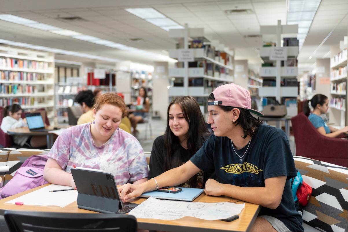 A group of students looking at a computer in Alkek. 