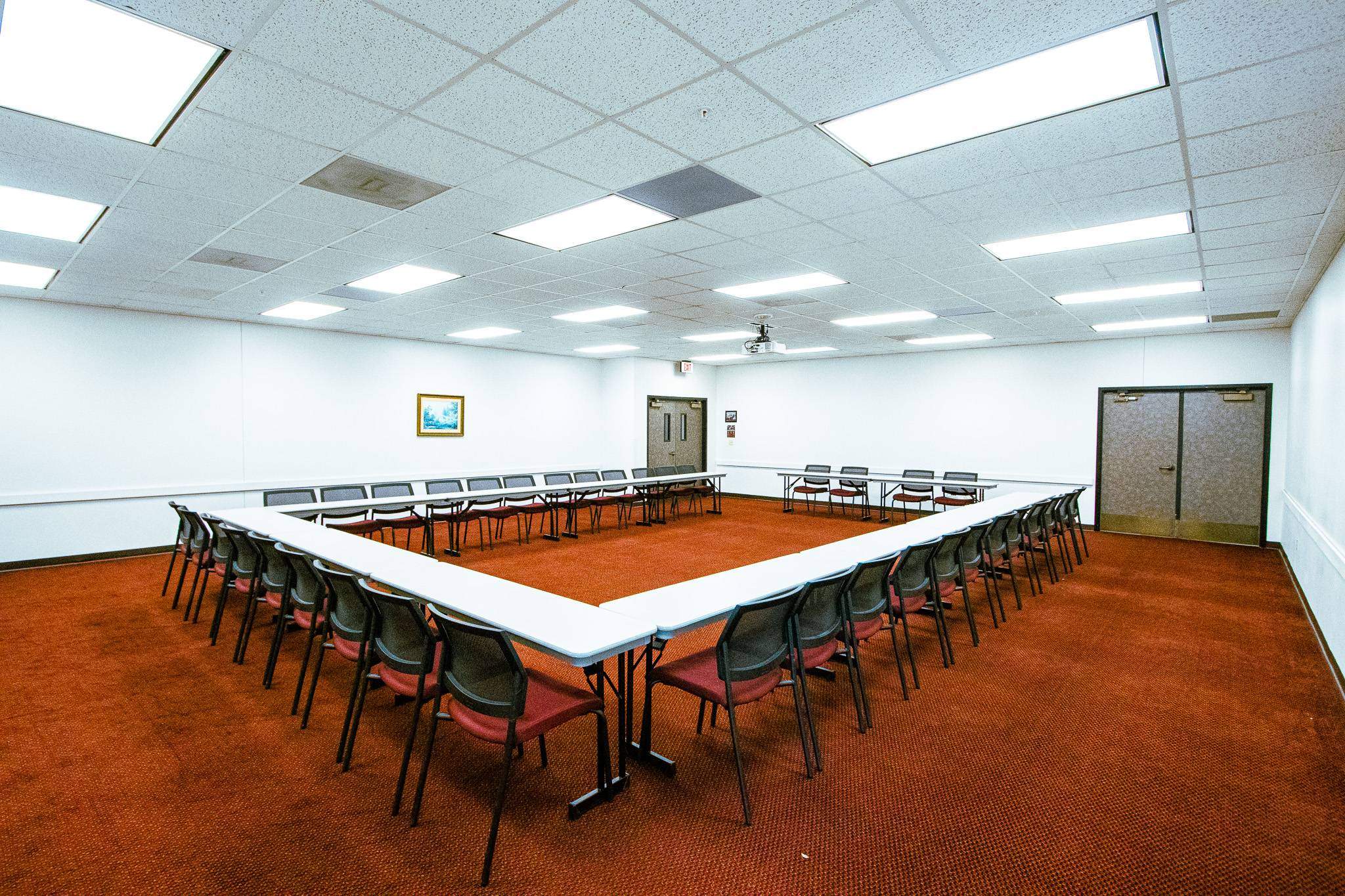 A room with a u-shaped table structure and chairs