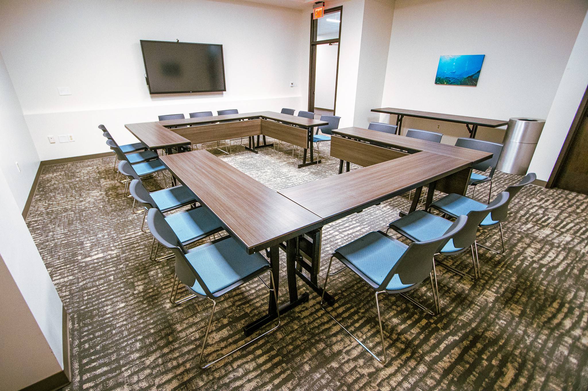 A room with a circular table structure and blue chairs