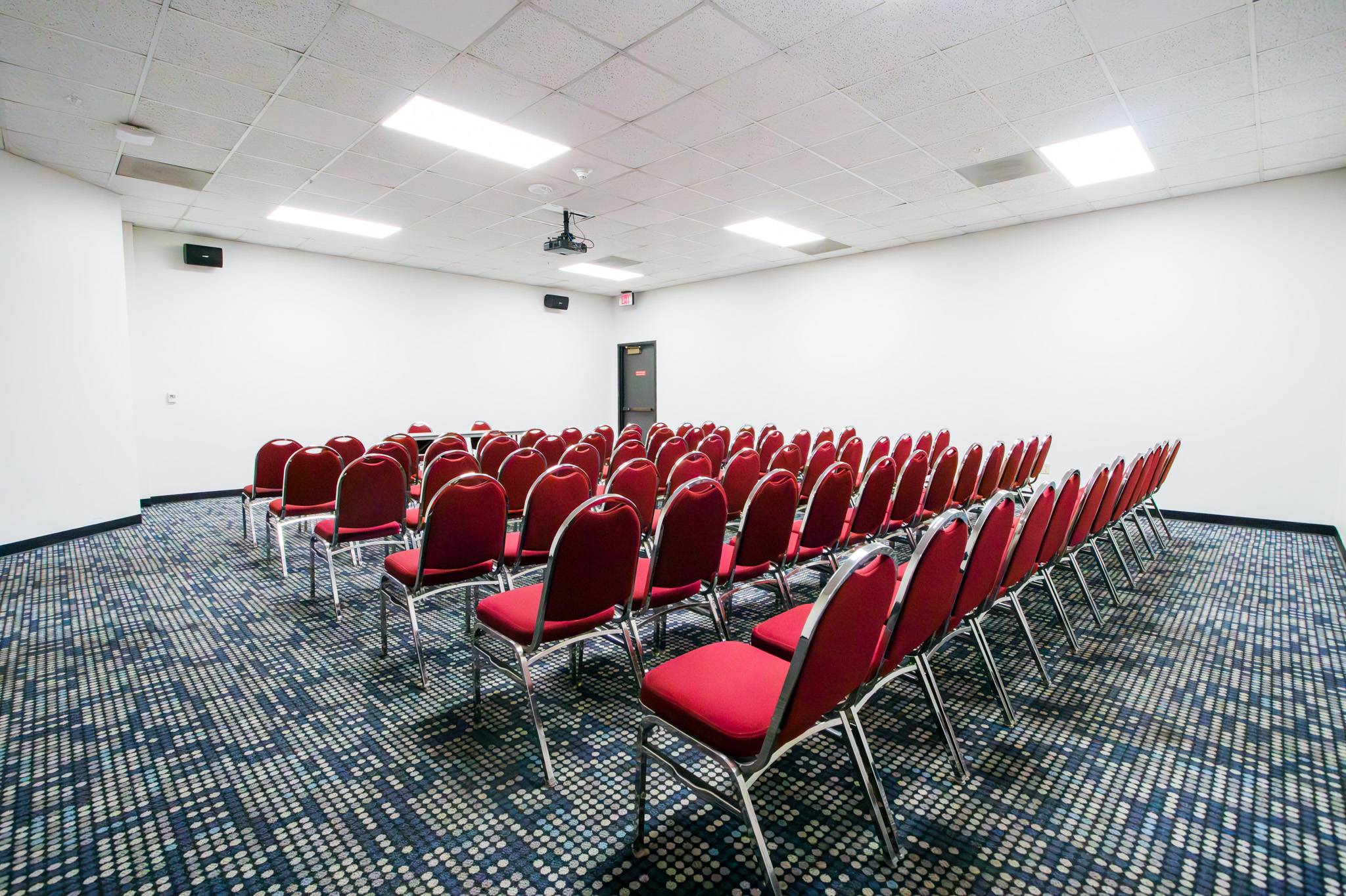 A room with rows of red chairs