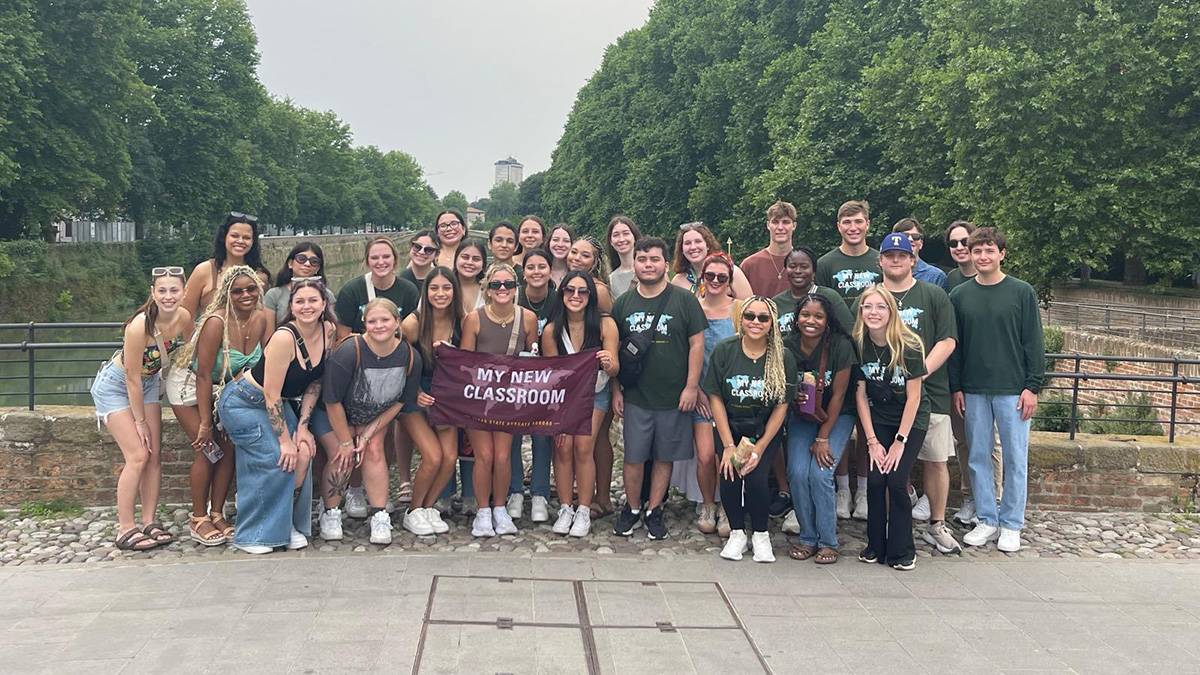 A large group of students pose for a picture in Italy.