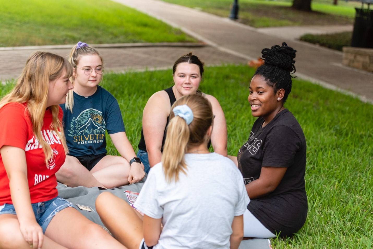 Group of students talking on the grass