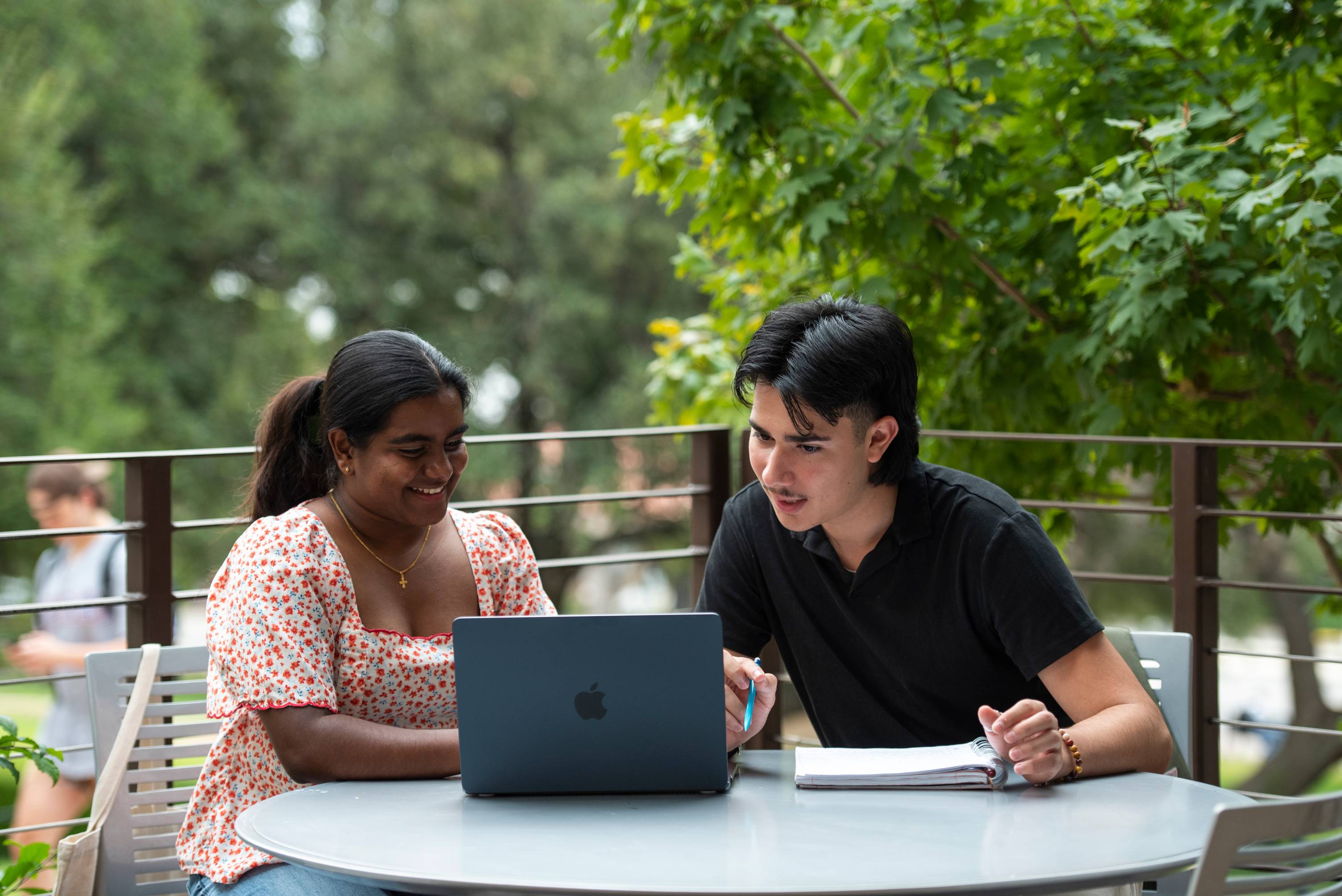 Students at table looking at laptop