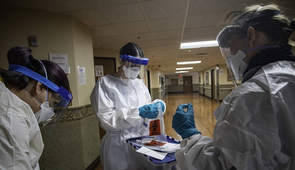 Nurses in protective equipment conducting covid-19 tests.